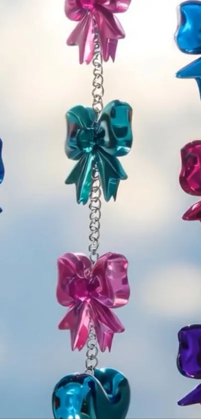 Colorful chain of metallic bows against light sky background.