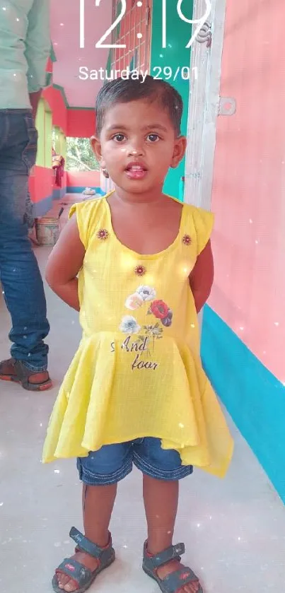 Child in a yellow dress with vibrant colors.