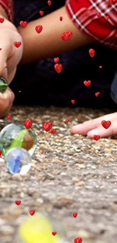 Hands playing marbles on a textured surface, capturing colorful stones.