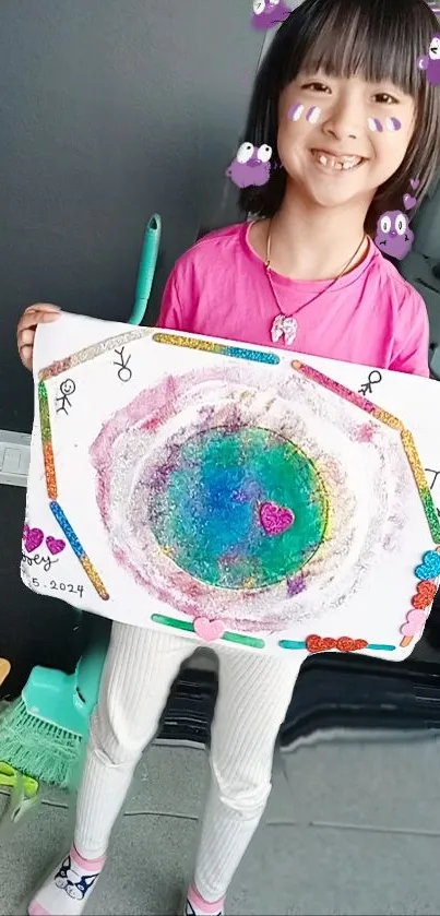 Child holding colorful painting with a cheerful smile.