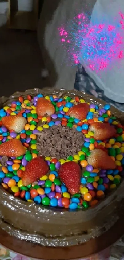 Chocolate cake with colorful candies and strawberries topping.