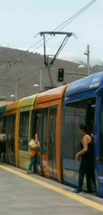 Colorful city tram with passengers boarding at a station.