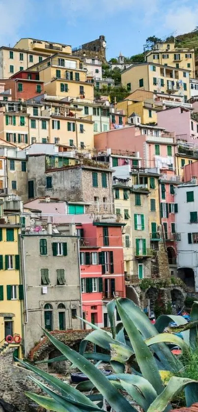 Colorful village houses with lush green plants and blue sky.