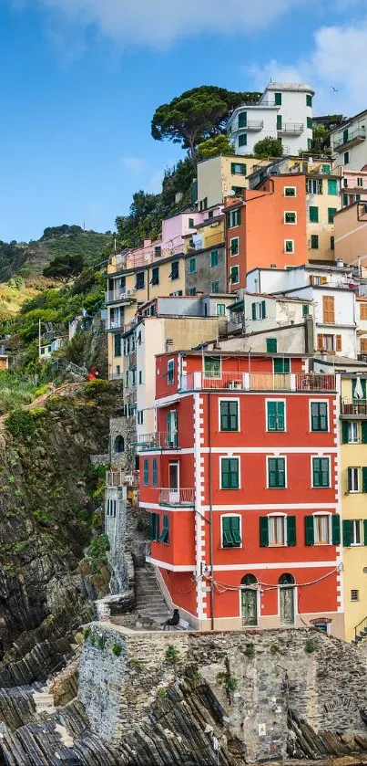 Colorful cliffside village by the sea with vibrant houses and blue ocean.