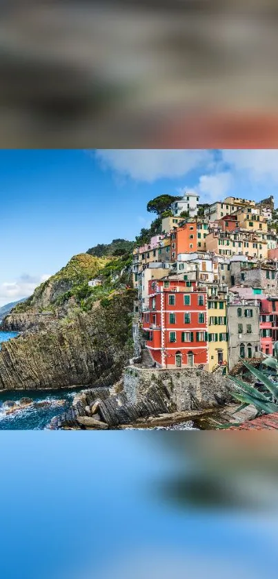 Vibrant coastal village with colorful buildings on a cliff overlooking the ocean.