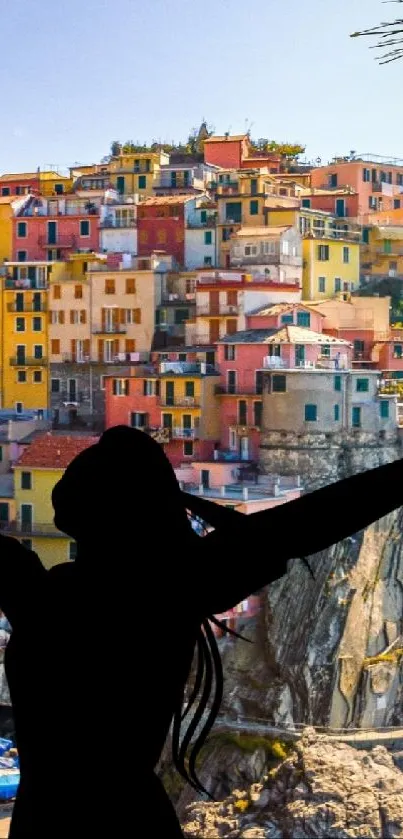 Vibrant coastal village with silhouette figure in the foreground.