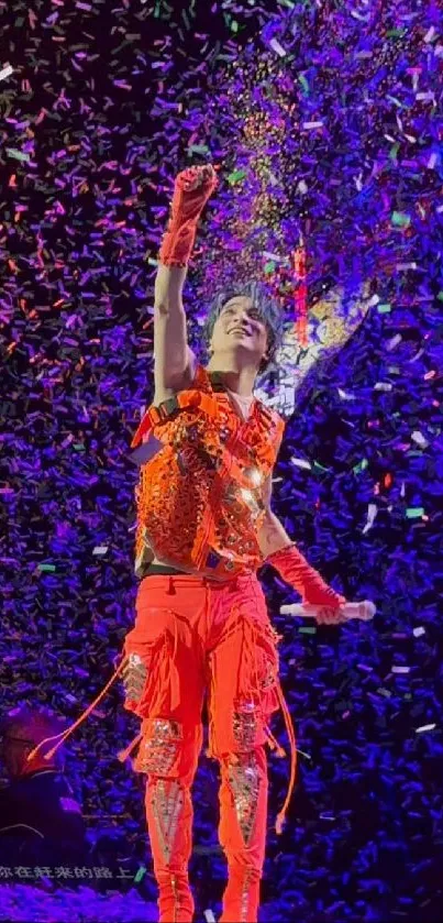 Person in red outfit under falling confetti on stage.