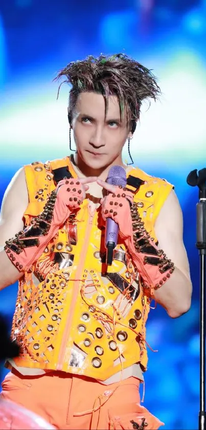 Bright concert stage with energetic performer in orange outfit.