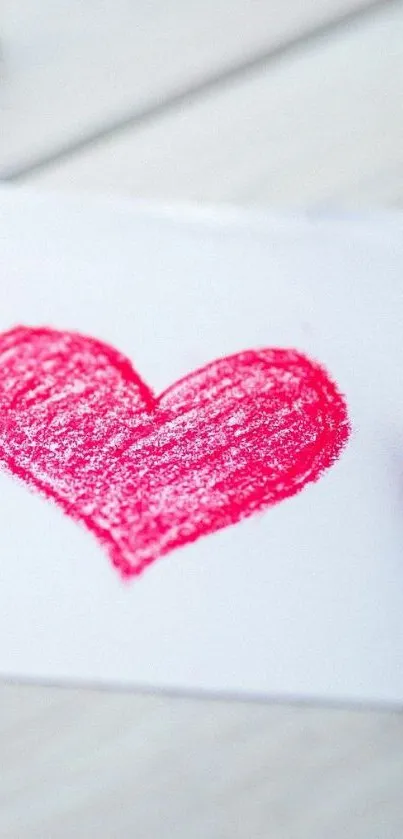 Artistic red crayon heart on white paper