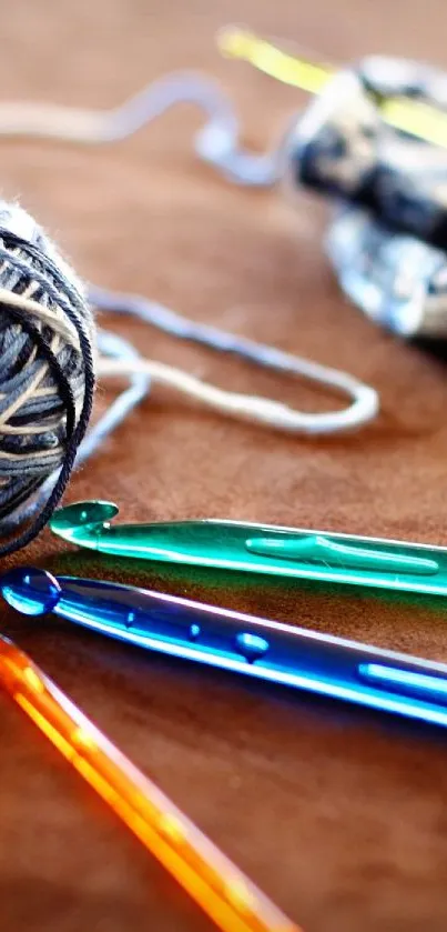 Colorful crochet hooks and yarn ball on a brown background.