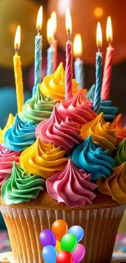 A colorful cupcake with frosting and lit candles, perfect for celebrations.