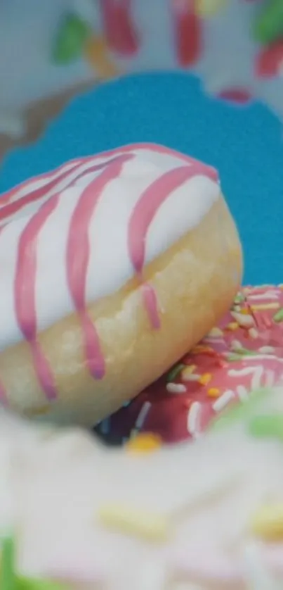 Colorful donuts with pink frosting and sprinkles against cyan blue background.