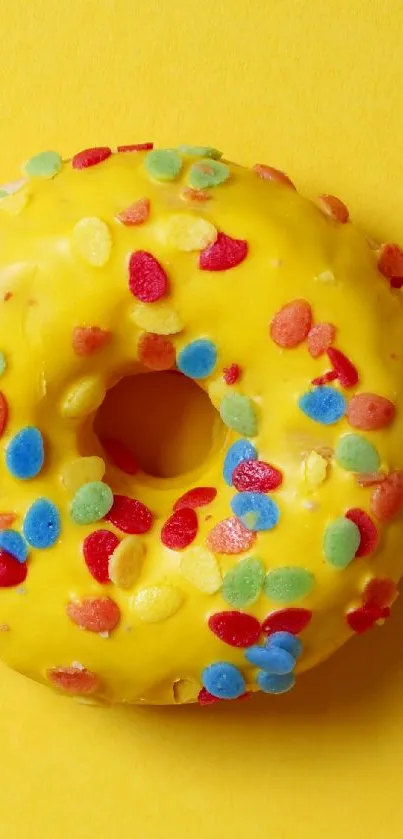 Colorful donut with sprinkles on yellow background.