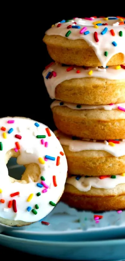 Stack of glazed donuts with colorful sprinkles on a plate.