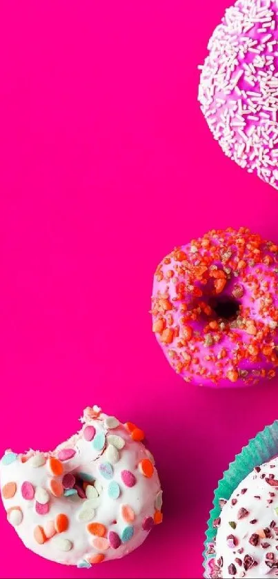 Colorful donuts on bright pink background mobile wallpaper.