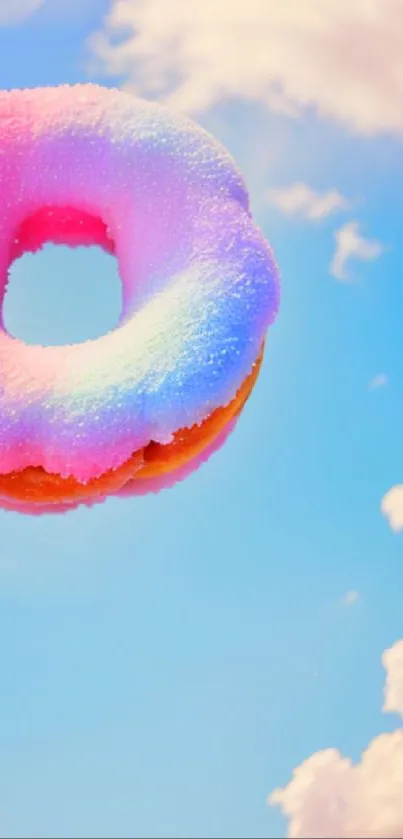 Colorful donut floats in a blue sky with fluffy clouds.