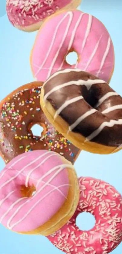 Assorted colorful donuts with pink, chocolate, and sprinkles on a blue background.