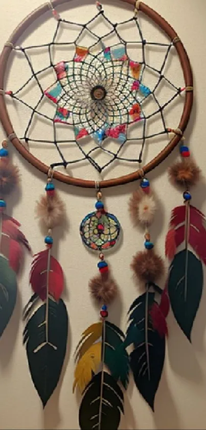 Colorful dreamcatcher with feathers and beads on a beige wall.