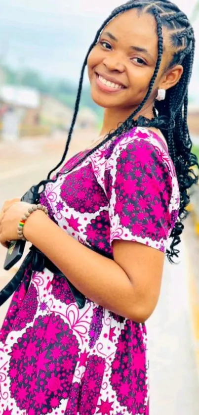 Smiling woman in colorful floral dress with braids.