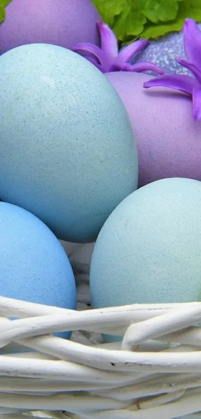 Colorful Easter eggs in a wicker basket with flowers.