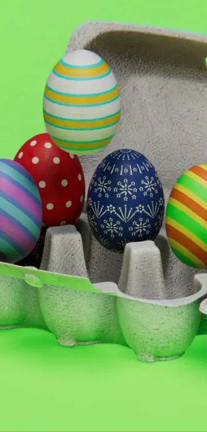 Colorful Easter eggs in carton on bright green background.