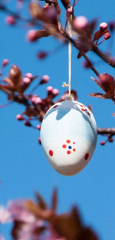 Colorful Easter eggs hanging on a branch against a blue sky.