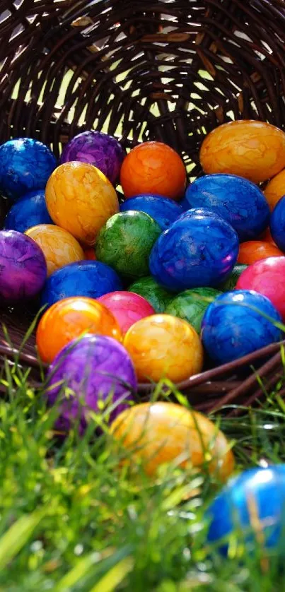 Colorful Easter eggs spilling from a wicker basket onto green grass.