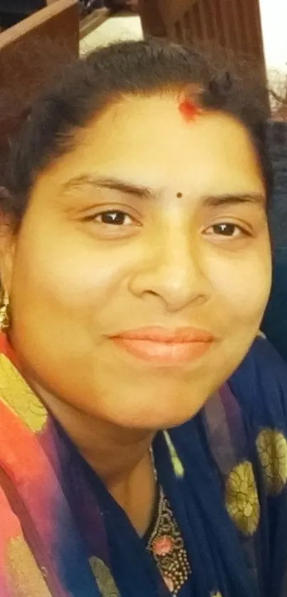 Portrait of a smiling woman in vibrant traditional attire.