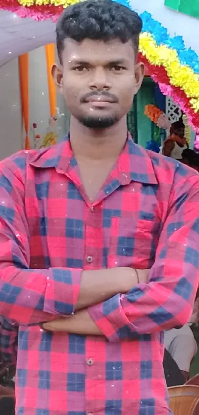 Person at a vibrant event with floral decorations and a red shirt.