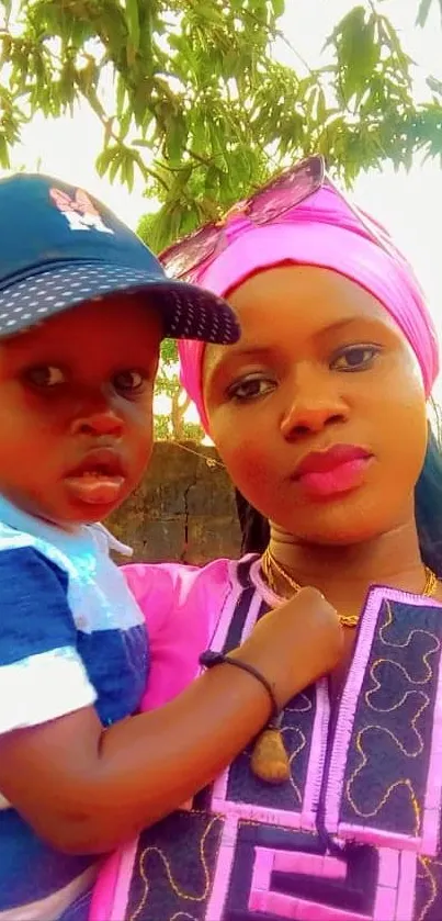 Family portrait with vibrant pink and blue outfits in the sunshine.