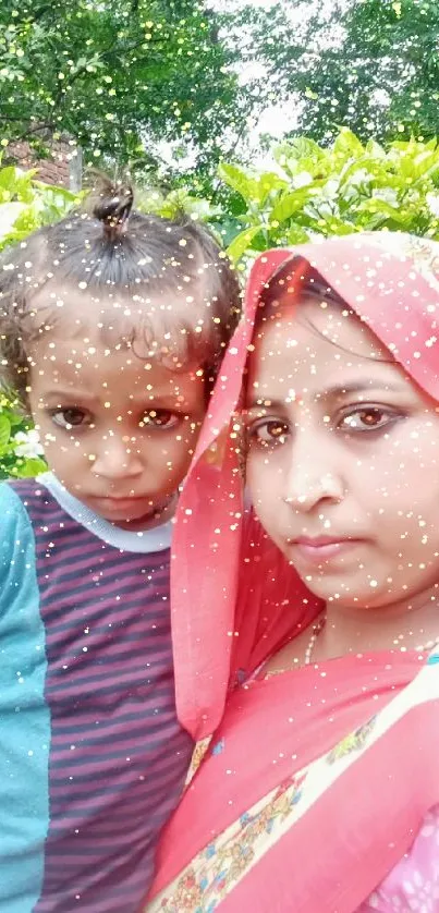 Mother and child in colorful attire with greenery background.