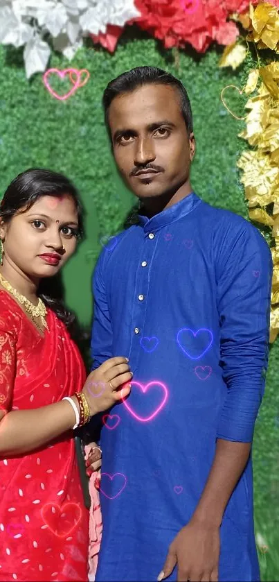 Festive couple standing together with colorful hearts and a green backdrop.