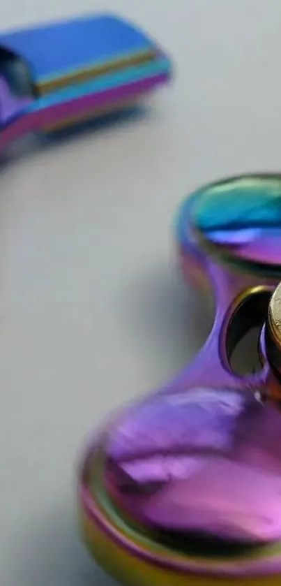 Closeup of a rainbow-colored fidget spinner with a metallic finish.