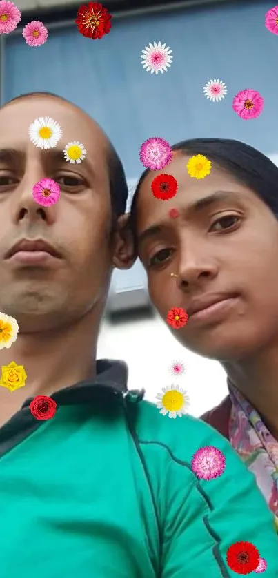 A couple's selfie with colorful flowers overlay.