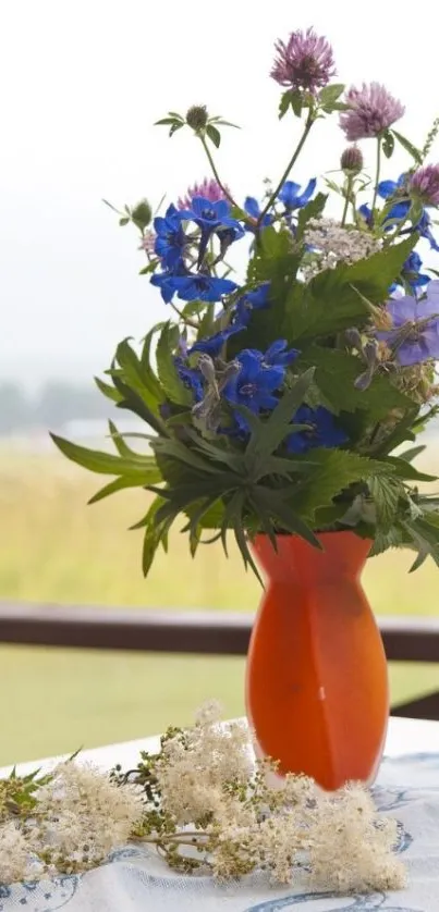 A vibrant bouquet of flowers in an orange vase on a table.