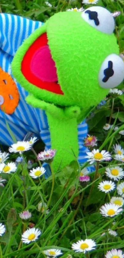 Green frog puppet amongst daisies in a vibrant field.