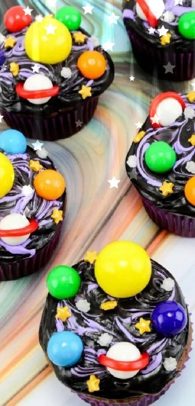 Galaxy-themed cupcakes with colorful candies and swirls on a mobile wallpaper.