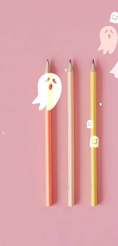 Three colorful pencils with ghost illustrations on a pink background.