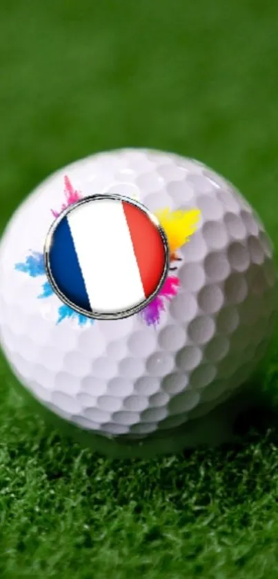 Golf ball with French flag and colorful splashes on green grass.