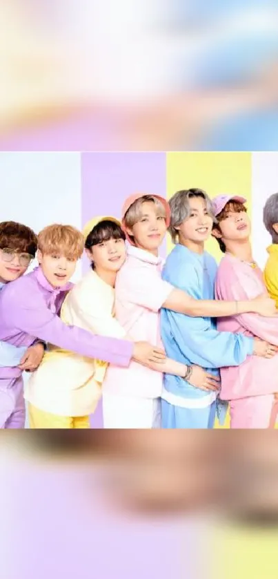 Colorful group hug in pastel outfits on vibrant background.