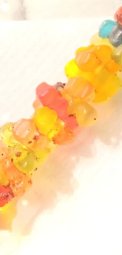 Colorful gummy bears aligned on a white backdrop.