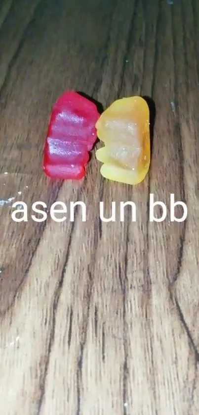 Two gummy bears on wooden surface.