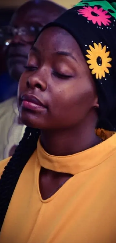 Vibrant image of a person with a floral headscarf and a yellow dress.