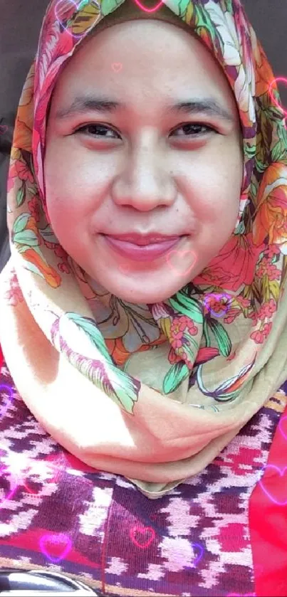 Person wearing a colorful headscarf, smiling in warm light.