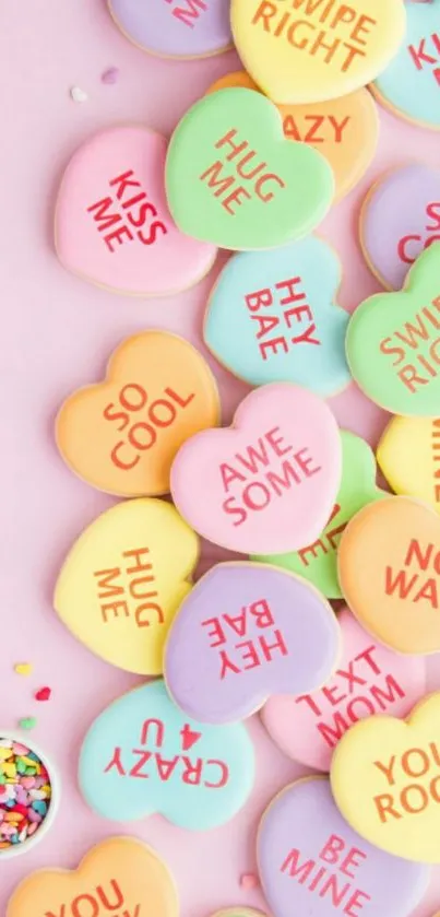 Vibrant candy heart cookies with messages on pink background.