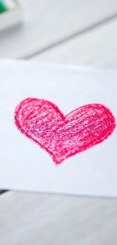 Colorful heart crayon drawing on wooden background.