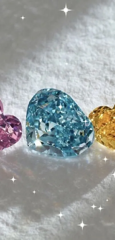 Three heart-shaped gemstones in pink, blue, yellow on a white background.