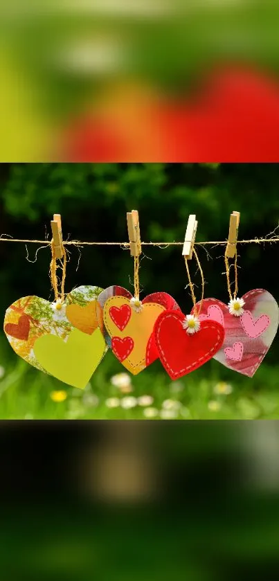 Colorful hearts hang on a line with a lush green backdrop.