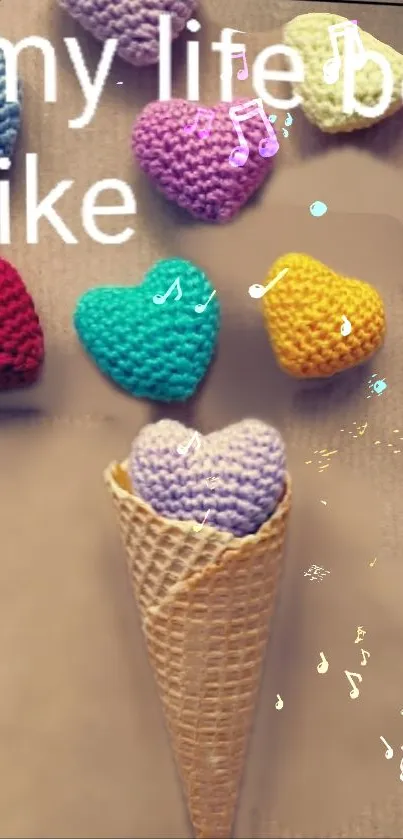 Crochet hearts in rainbow colors forming an ice cream cone on a beige background.