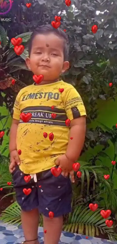 Playful child with red hearts background on a green leafy wall.